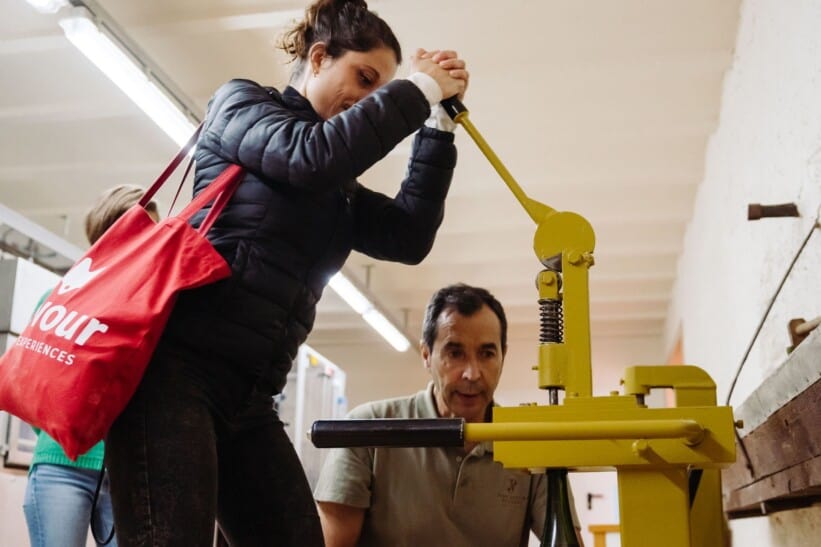 A woman uses a wine press