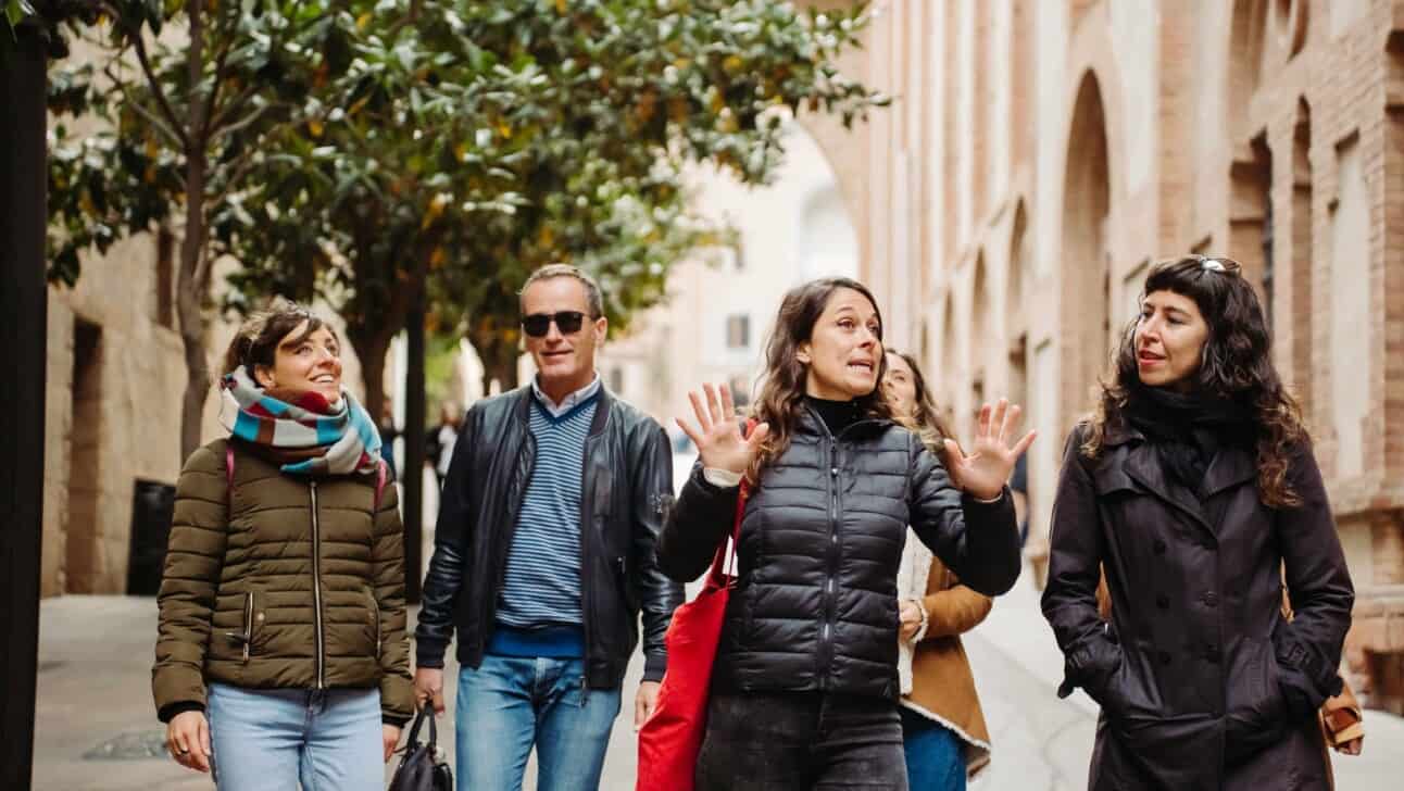 A guide leads a group on a walking tour of the Montserrat Monastery