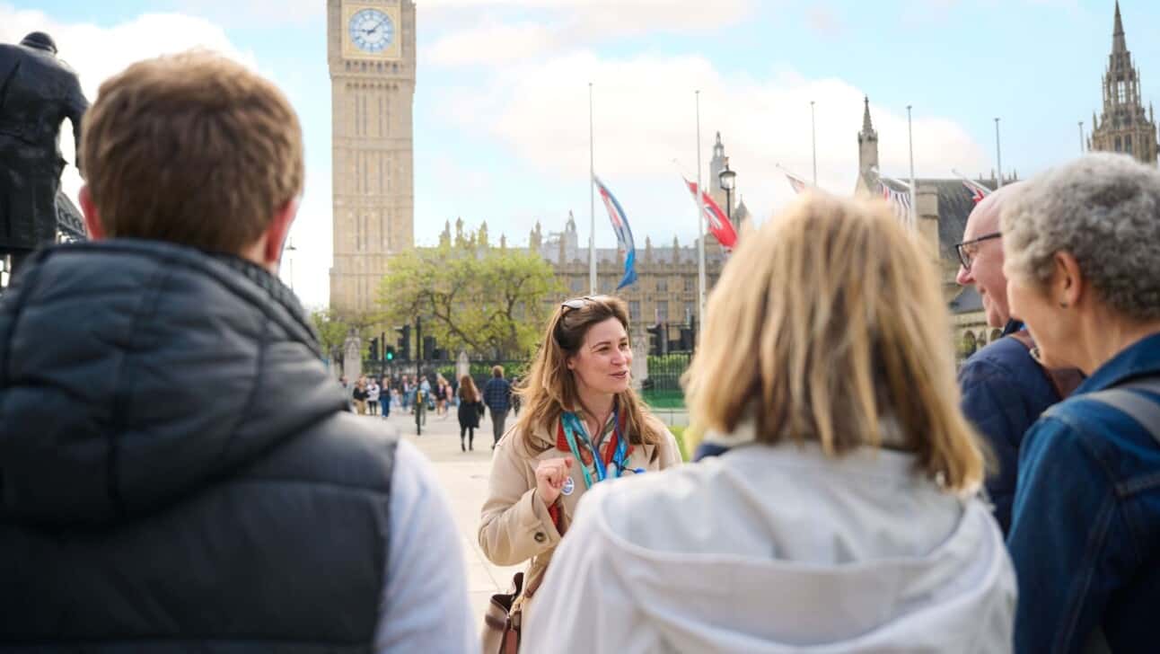 A blue badge guide in London leads a group near Big Ben