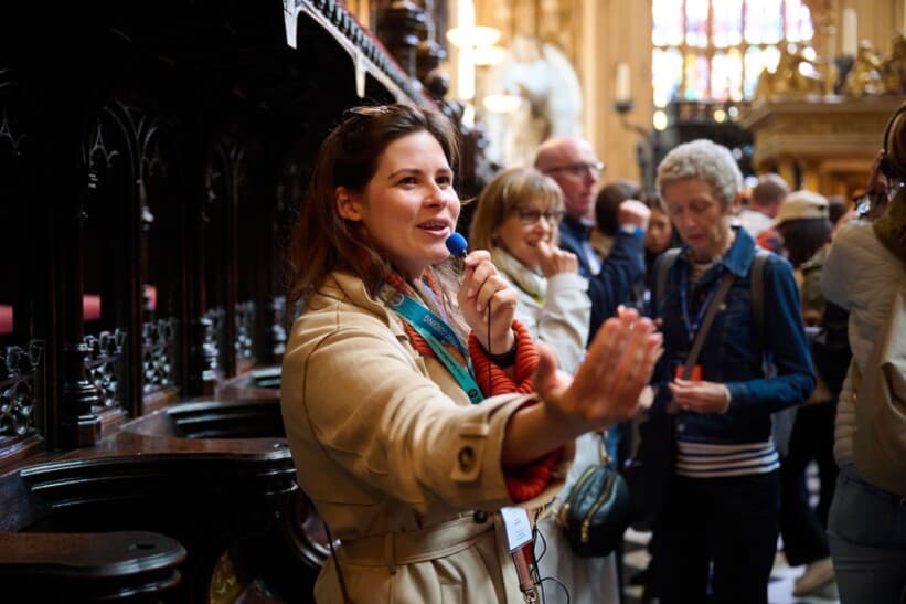A blue badge guide leads a group through the royal tombs inside Westminster Abbey