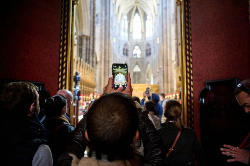 A guest takes a photo on a mobile device inside Westminster Abbey