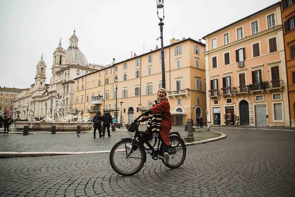 a girl rides a bike in Rome