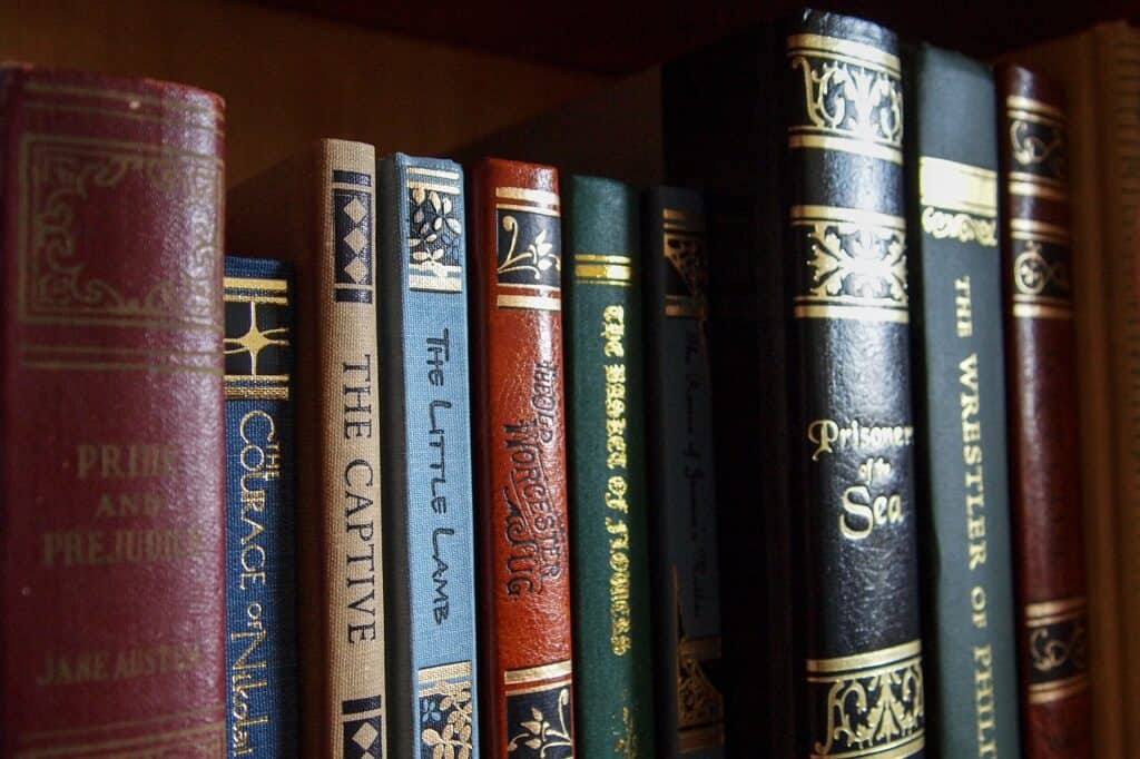 A set of old books on a bookshelf, including a Jane Austen novel
