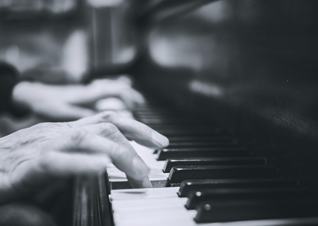 hands on a piano in a black and white photo