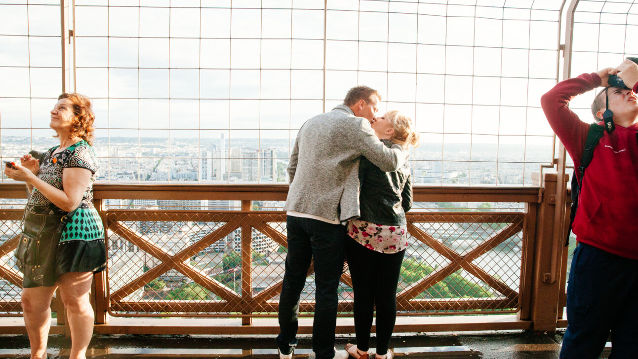 A couple kissing on the Eiffel Tower