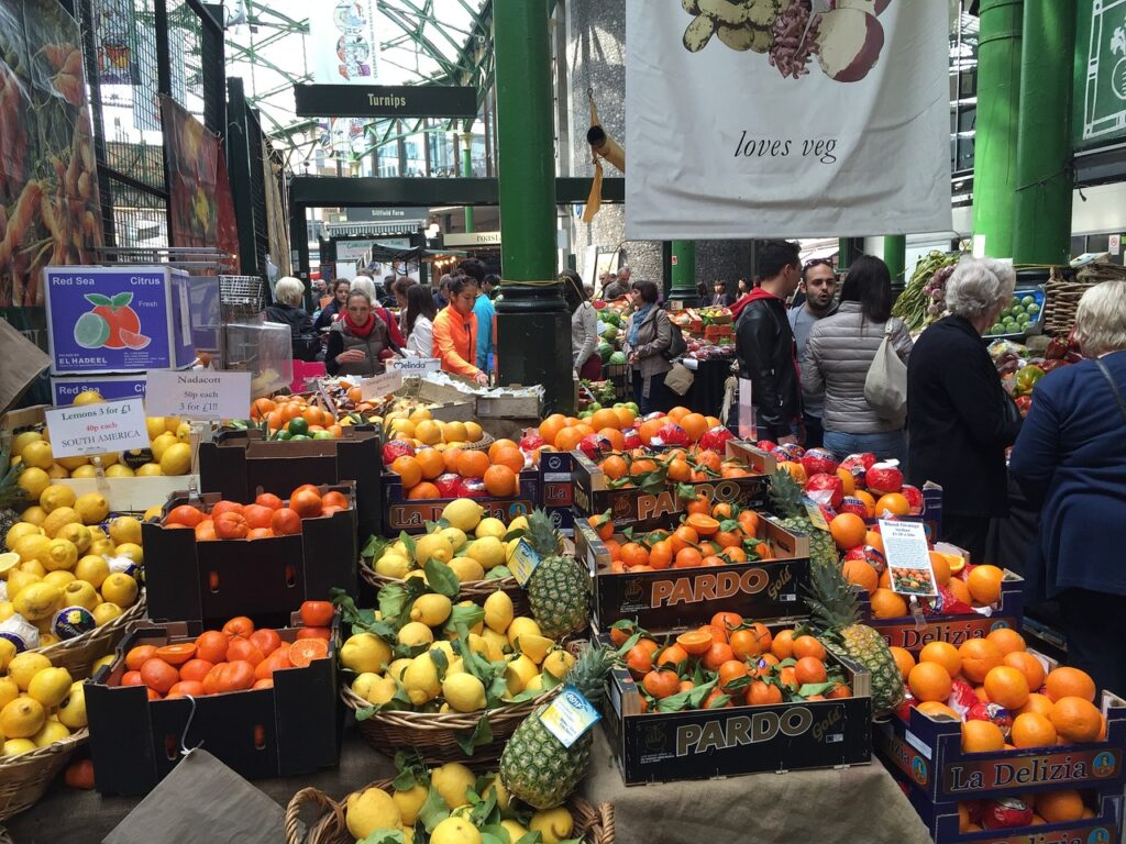 Fruit stalls at Borough Market in London featuring varying fruits in baskets
