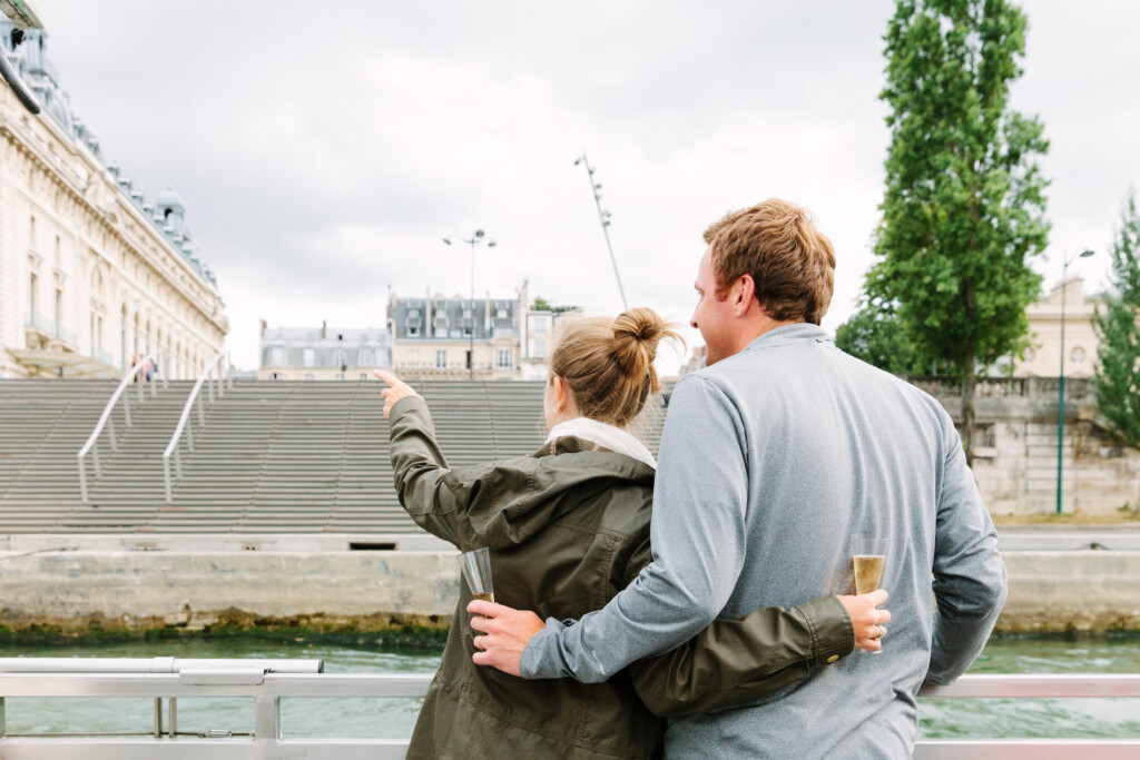 A couple with champagne on a boat looking at the sites in Paris