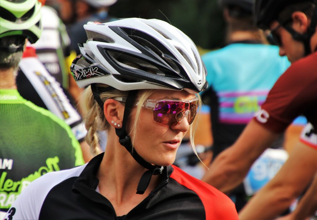 Blonde cyclist wearing a silver helmet and sunglasses