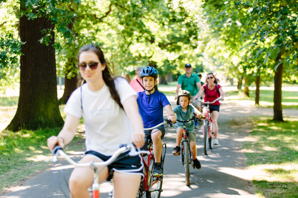 A family riding bike through the Royal Parks in London